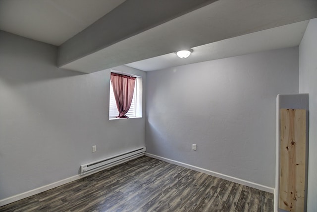 spare room with baseboard heating and dark wood-type flooring