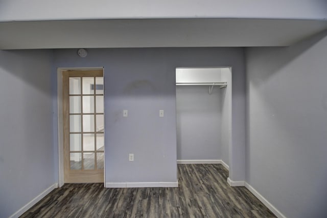 unfurnished bedroom featuring dark hardwood / wood-style flooring and a closet