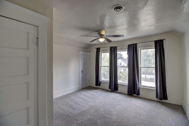 unfurnished room featuring ceiling fan, lofted ceiling, light carpet, and a textured ceiling