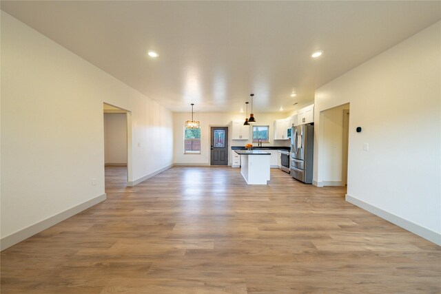 unfurnished living room with light hardwood / wood-style flooring and sink