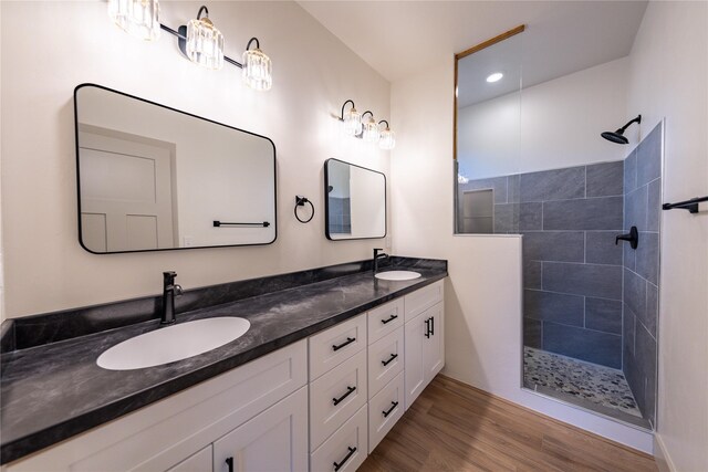 bathroom featuring vanity, hardwood / wood-style floors, and a tile shower