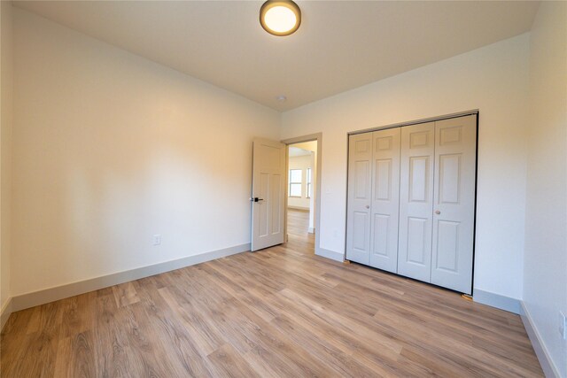 unfurnished bedroom featuring a closet and light hardwood / wood-style flooring