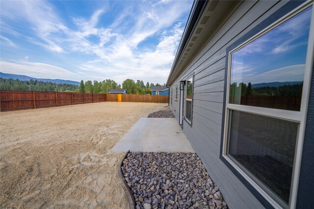 view of yard featuring a patio and a mountain view