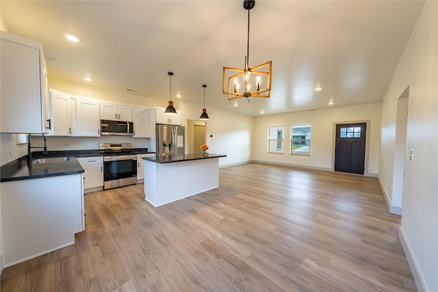 kitchen featuring an inviting chandelier, appliances with stainless steel finishes, a center island, sink, and white cabinetry