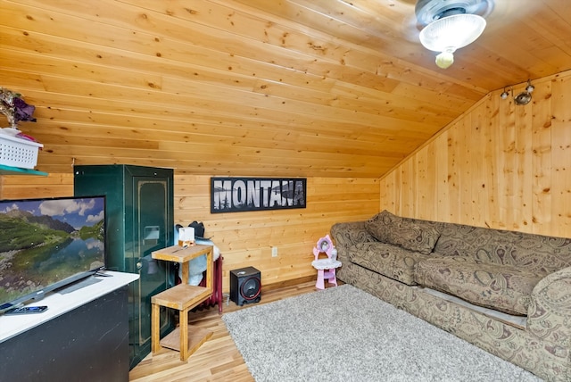 living room with lofted ceiling, wooden walls, light hardwood / wood-style floors, and wooden ceiling