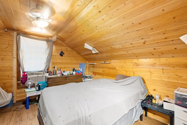 bedroom featuring light wood-type flooring, wooden ceiling, lofted ceiling, and wood walls