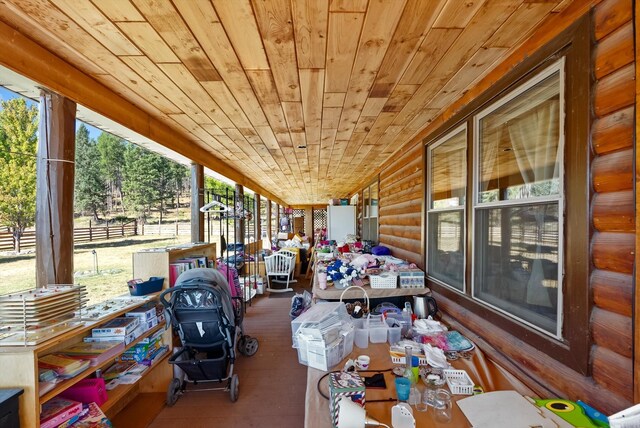 unfurnished sunroom featuring wood ceiling and a wealth of natural light