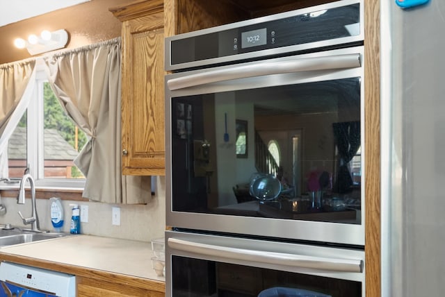 interior space featuring sink, stainless steel double oven, and dishwasher