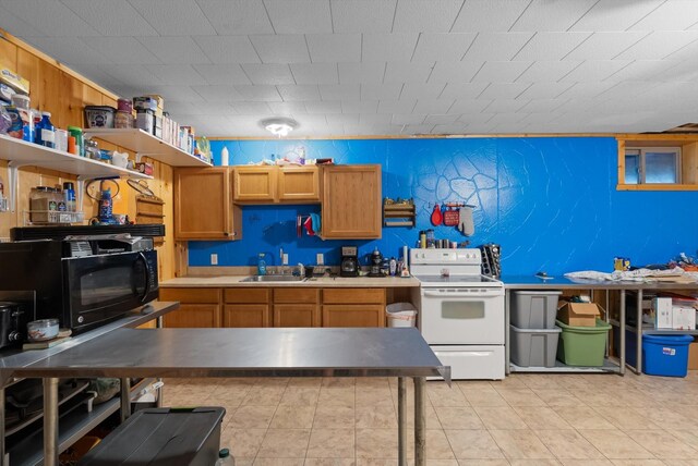 kitchen with sink, light tile patterned floors, and white electric stove