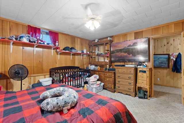 carpeted bedroom with wood walls