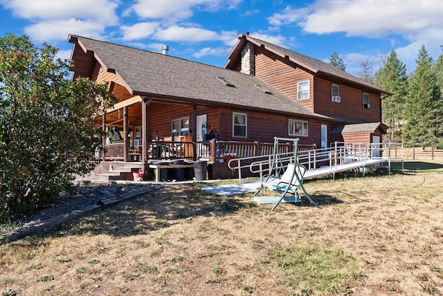 rear view of property with a yard and a deck