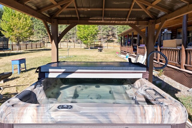 view of patio / terrace featuring a hot tub and a gazebo