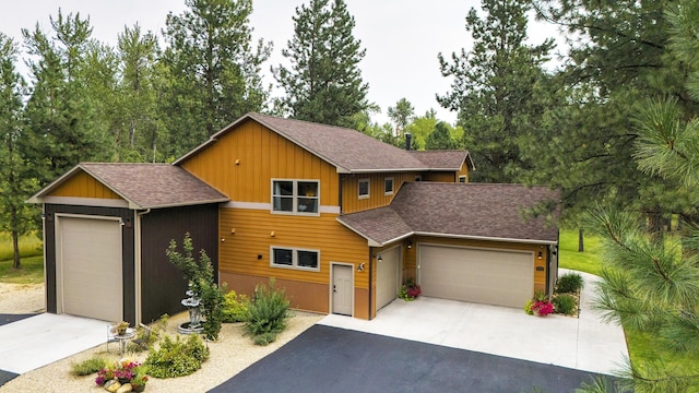 view of front of property featuring a shingled roof, driveway, board and batten siding, and an attached garage