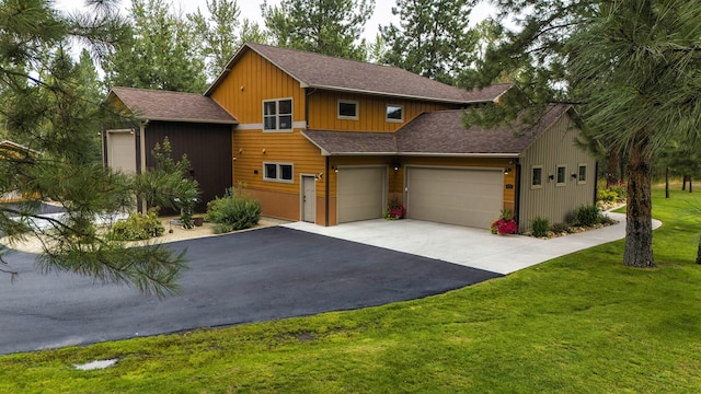 view of front facade with a garage, roof with shingles, driveway, and a front lawn