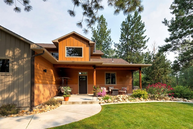 view of front facade with board and batten siding, a shingled roof, and a front lawn