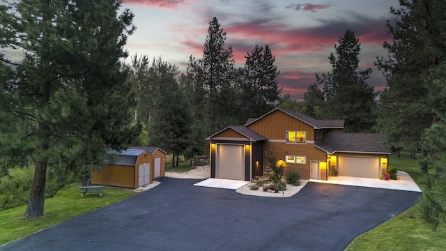 view of front facade featuring a garage, aphalt driveway, board and batten siding, and a front yard