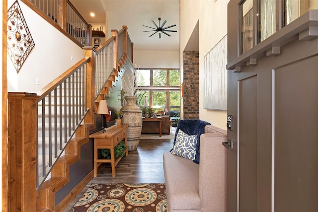 entryway with a towering ceiling, brick wall, and wood-type flooring