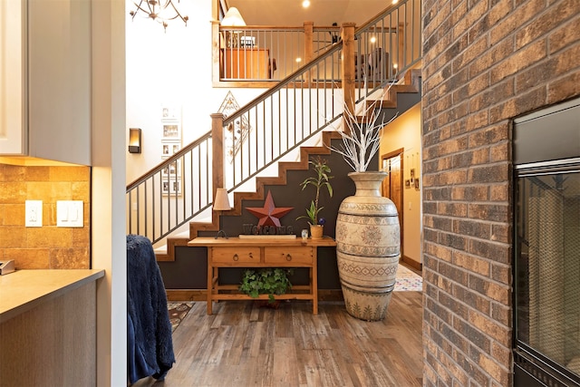 stairway featuring brick wall and hardwood / wood-style floors