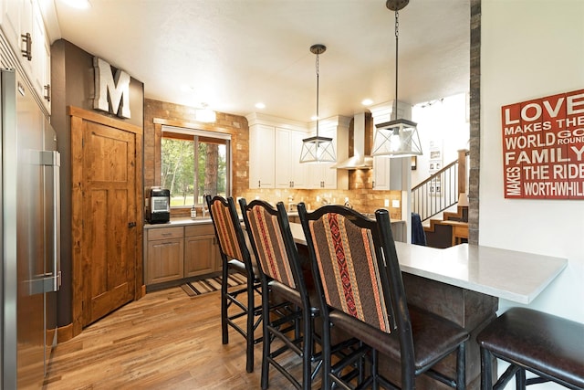 dining space with light wood-type flooring, recessed lighting, and stairs