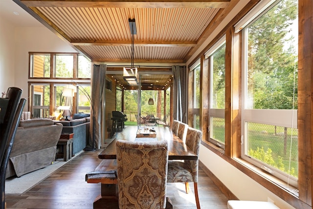 sunroom with beamed ceiling, plenty of natural light, and wooden ceiling