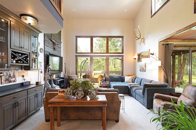 living room with light carpet and a towering ceiling