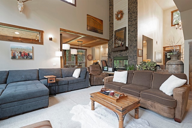 carpeted living room with a towering ceiling, beamed ceiling, and a fireplace