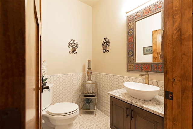 bathroom featuring tile patterned floors, tile walls, vanity, and toilet