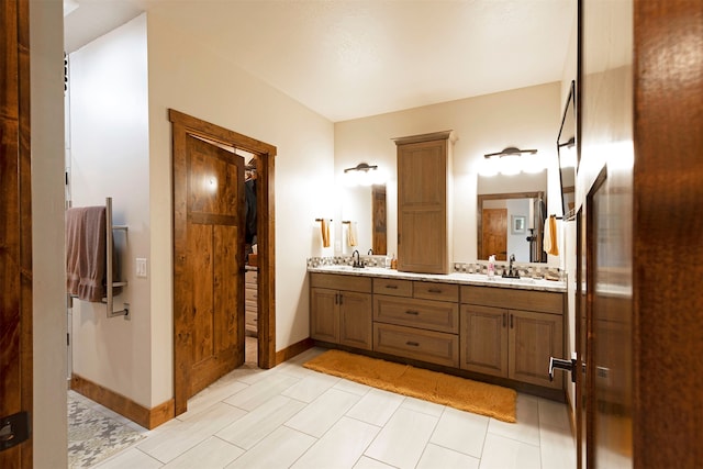 bathroom with tile patterned floors and dual bowl vanity