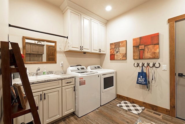 laundry room featuring dark wood-type flooring, sink, cabinets, and separate washer and dryer