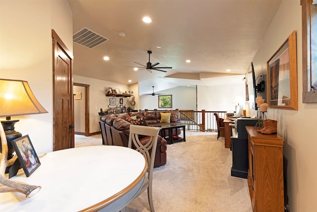 dining room featuring ceiling fan, vaulted ceiling, and light carpet