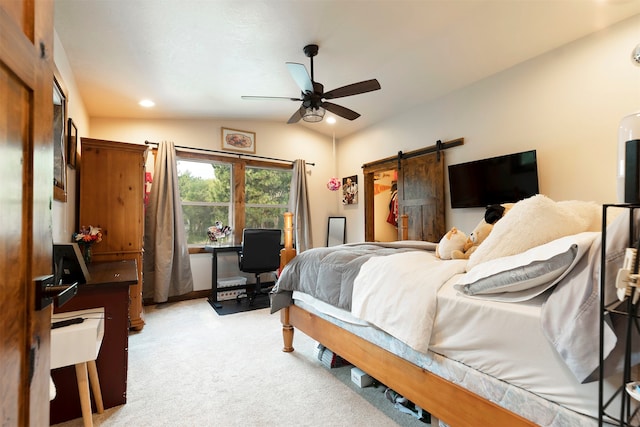 carpeted bedroom featuring ceiling fan, a barn door, and lofted ceiling