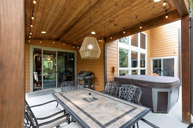 exterior space featuring outdoor dining area, area for grilling, and a hot tub