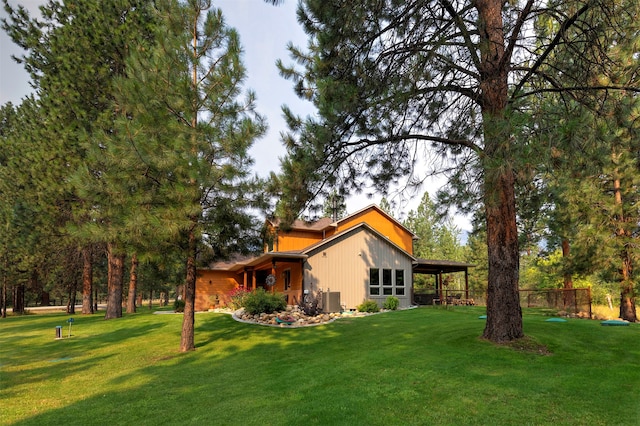 view of side of home with central AC and a lawn