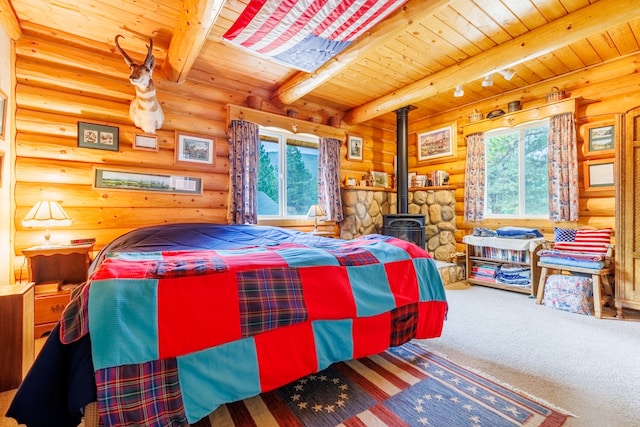 carpeted bedroom with a wood stove, rustic walls, beamed ceiling, and wood ceiling