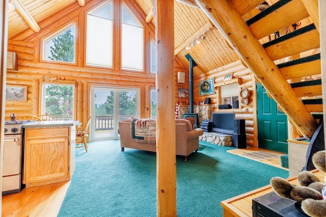 carpeted living room featuring wooden ceiling, high vaulted ceiling, a wood stove, log walls, and beamed ceiling