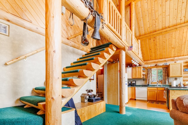 stairs with wood ceiling, hardwood / wood-style floors, rail lighting, high vaulted ceiling, and sink