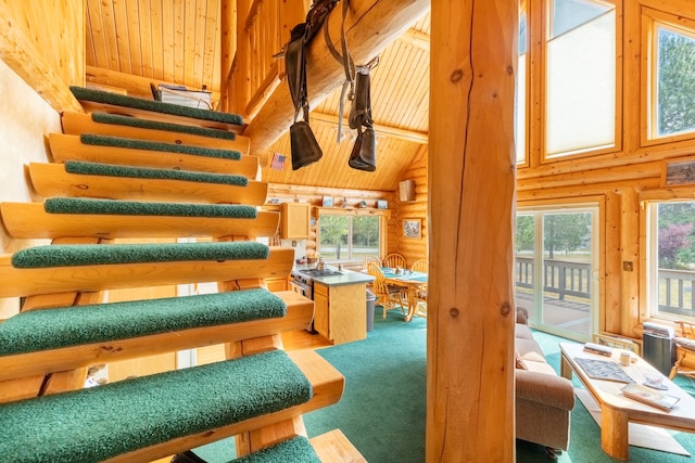 interior space featuring log walls, wooden ceiling, high vaulted ceiling, and carpet floors