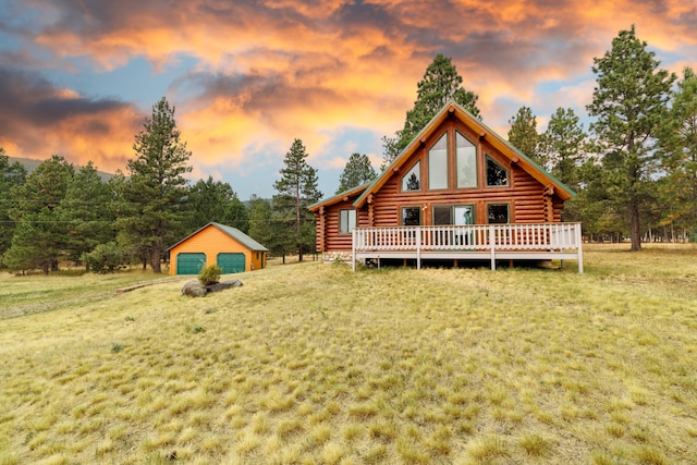 log-style house featuring an outdoor structure, a deck, a lawn, and a garage