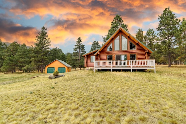 rear view of house with a wooden deck, a yard, log siding, and a garage