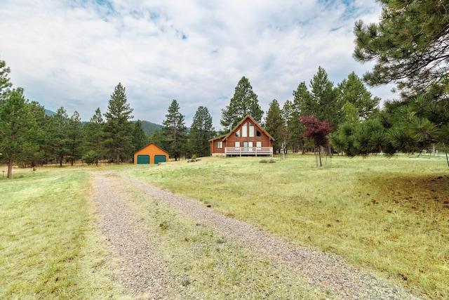 view of yard with a rural view, an outbuilding, and a deck