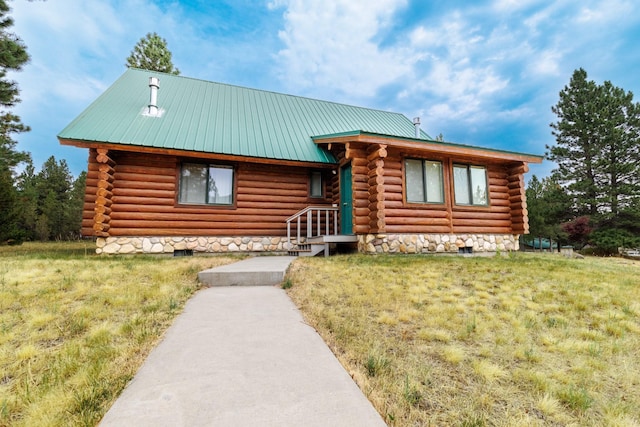 cabin with log exterior, crawl space, a front lawn, and metal roof