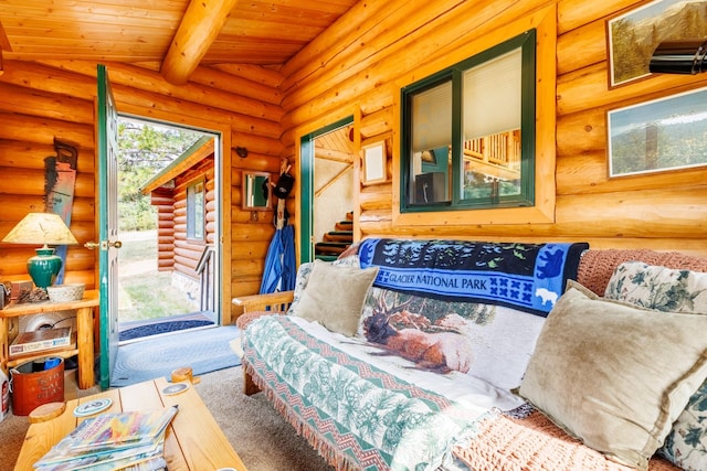 living area featuring beamed ceiling, carpet floors, wood ceiling, log walls, and stairs