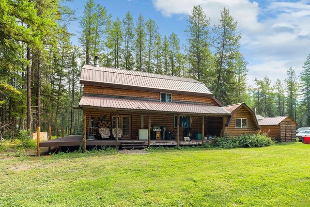 back of house featuring a storage unit and a yard