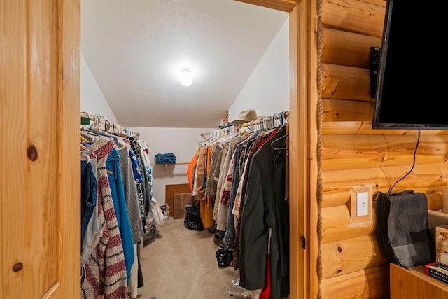 walk in closet with carpet floors and vaulted ceiling