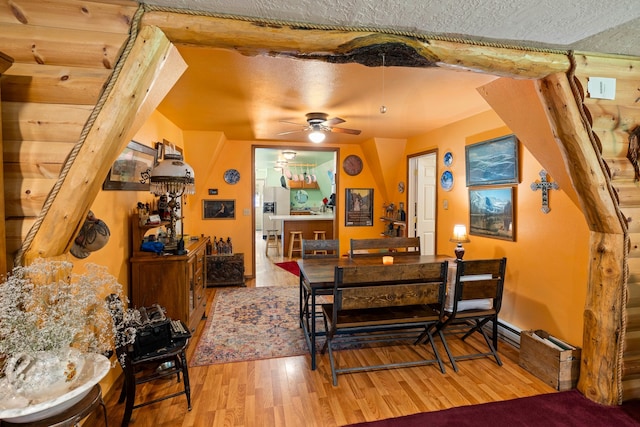 dining space with ceiling fan, wood-type flooring, and a textured ceiling