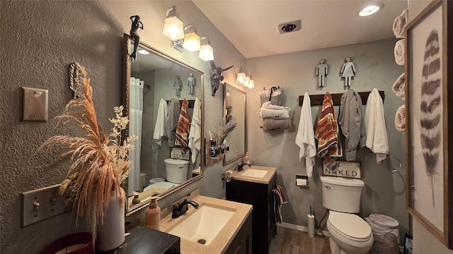 202 Lakeshore Dr, Kalispell, MT 59901 - full bathroom featuring a sink, toilet, wood finished floors, and two vanities
