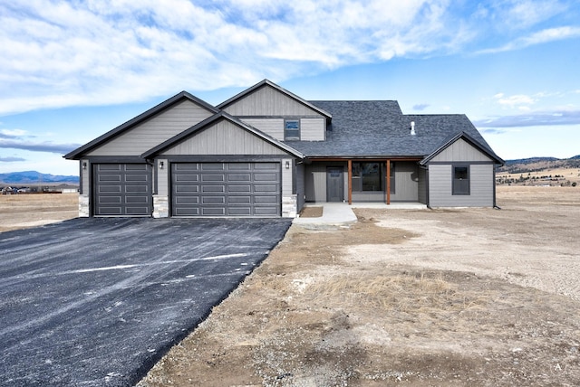 view of front of home with a mountain view, covered porch, and a garage