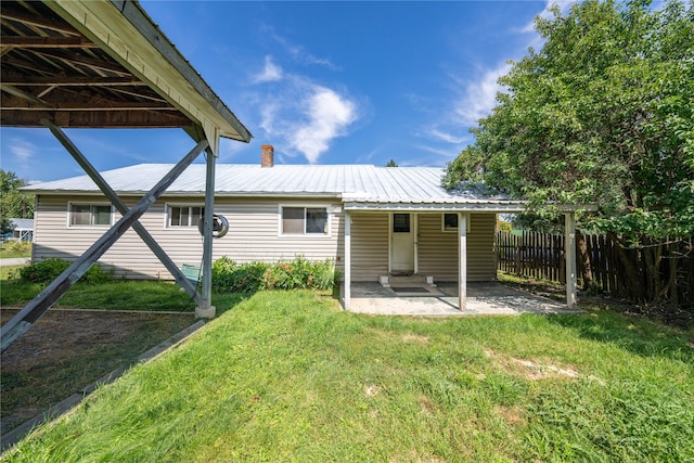 back of house with a patio and a yard