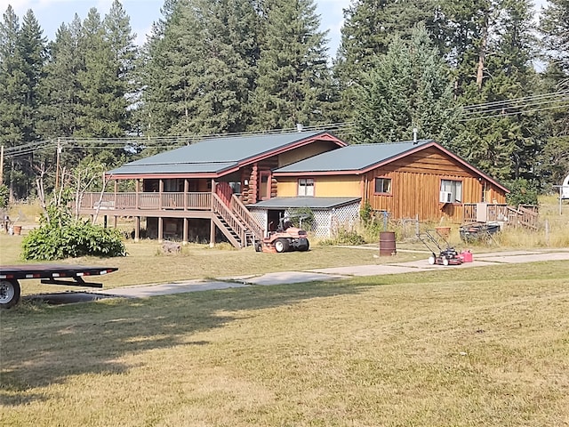 rear view of property with a yard and a wooden deck