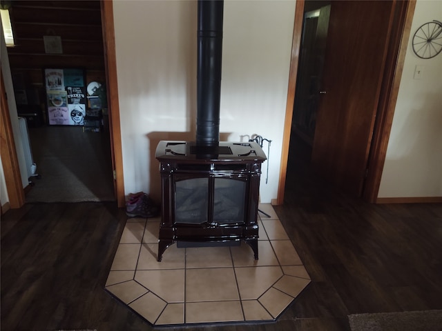 room details with a wood stove, radiator heating unit, and hardwood / wood-style flooring